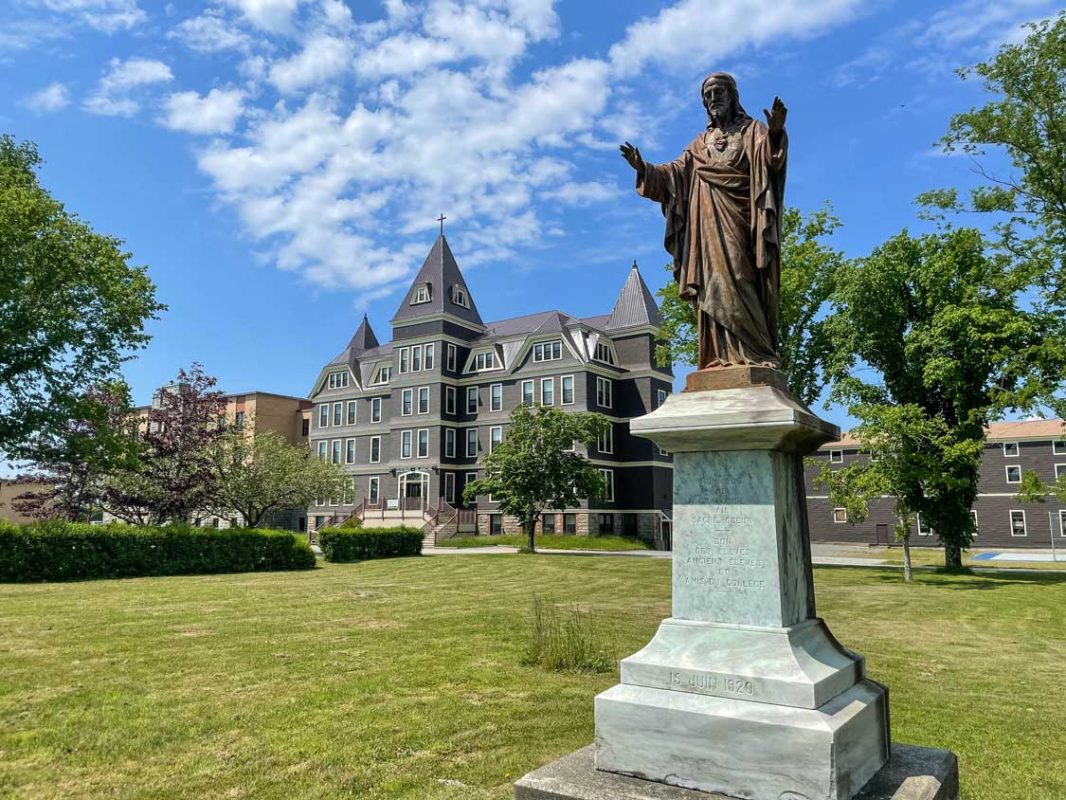 A statue of Jesus with his hands outstetched at Universite Sainte-Anne in Nova Scotia