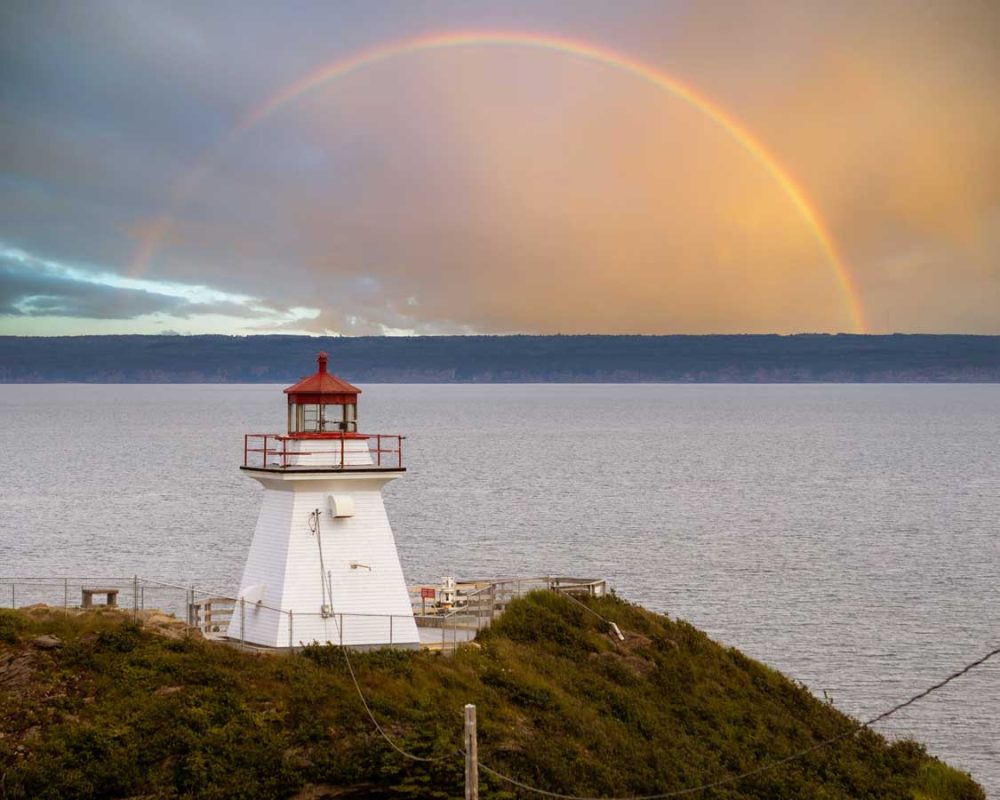 A rainbow in the sky over the Cape Enrage Lighthouse in New Brunswick