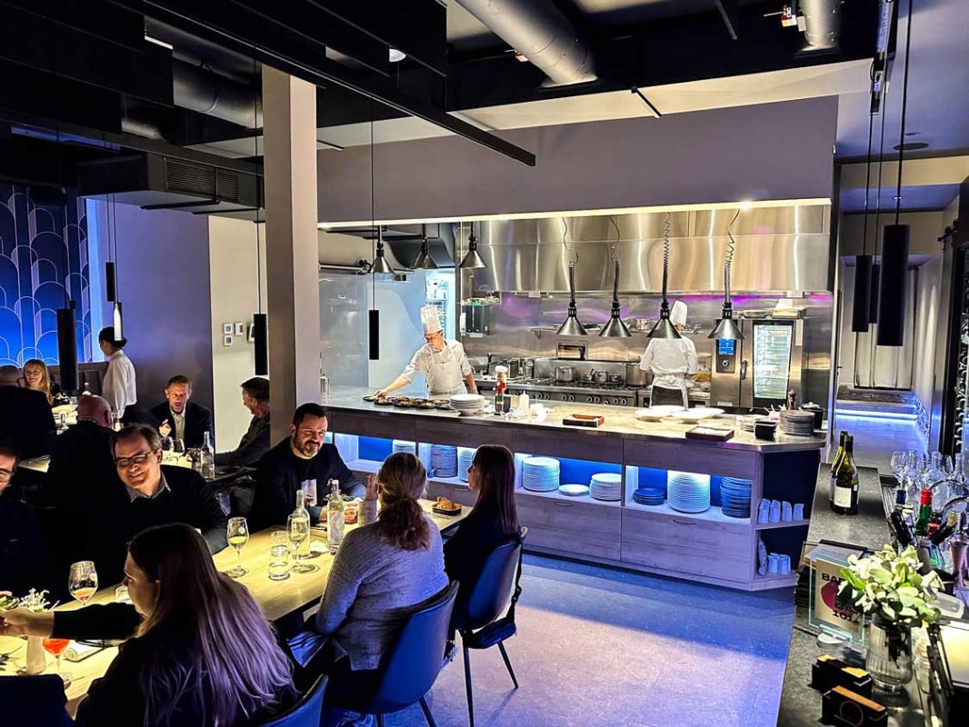 Diners enjoy a meal in front of the open kitchen of Le 101 Restaurant de Quartier in Quebec City
