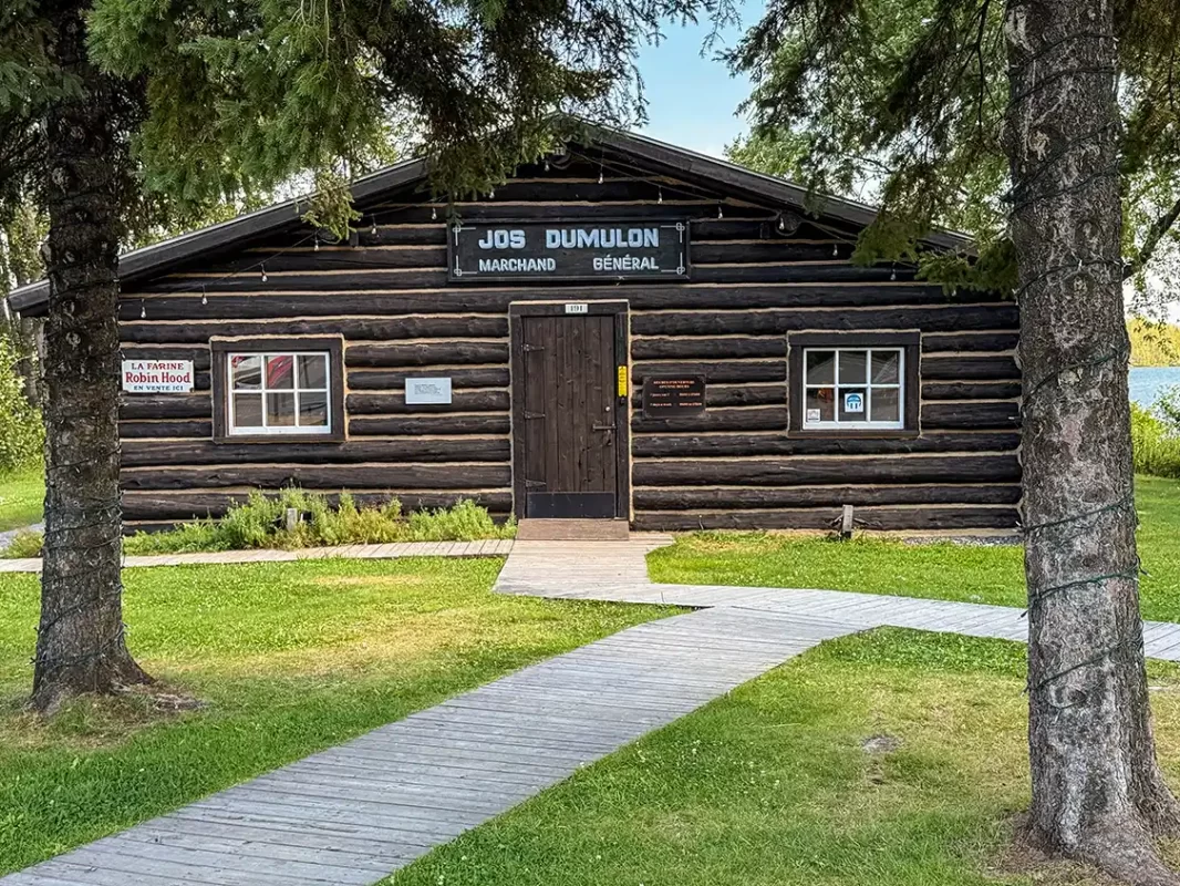 A wood cabin with a sign saying Jos Dumulon Magazin General