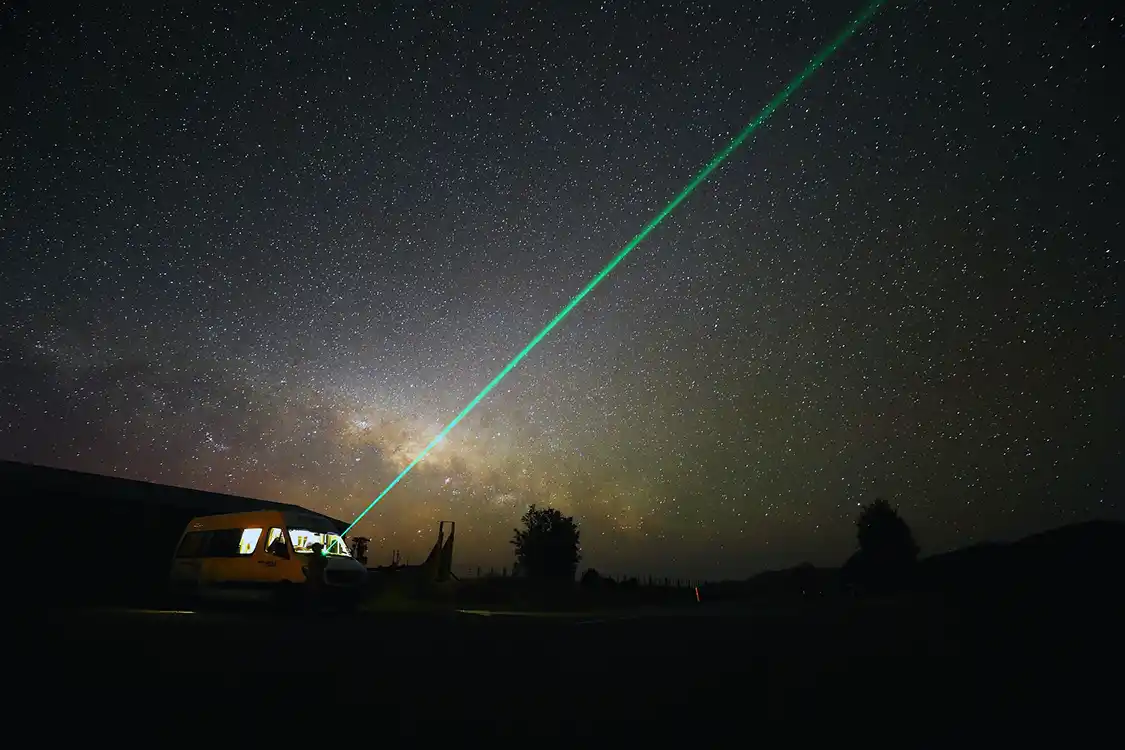 A powerful stargazing laser shining into a dark sky